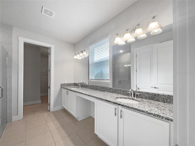 bathroom featuring vanity, tile patterned floors, and a shower with shower door