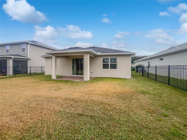 back of property with a yard and a patio