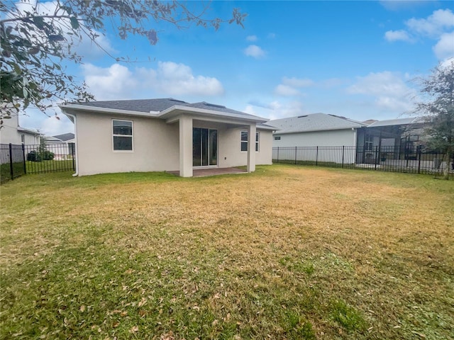 rear view of property with a lawn