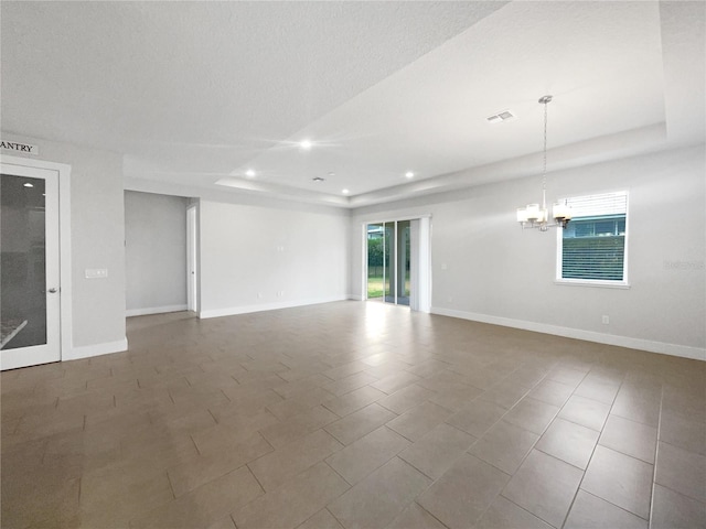 empty room featuring a chandelier and a textured ceiling