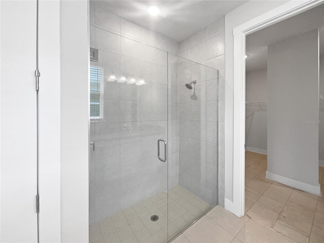 bathroom featuring a shower with shower door and tile patterned flooring