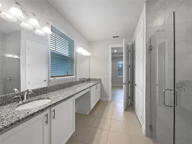 bathroom with walk in shower, tile patterned floors, and vanity