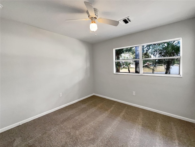 carpeted empty room featuring ceiling fan and a wealth of natural light