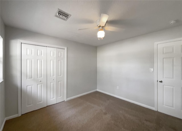 unfurnished bedroom with dark carpet, a closet, and ceiling fan