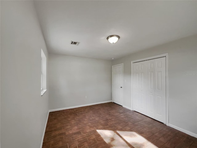 unfurnished bedroom with dark wood-type flooring