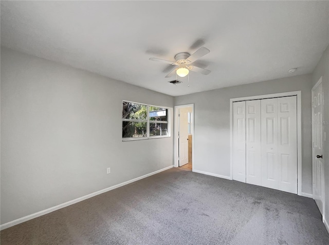 unfurnished bedroom with dark colored carpet, ceiling fan, and a closet