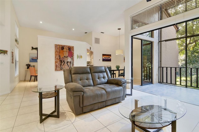 living room with a high ceiling and light tile patterned flooring