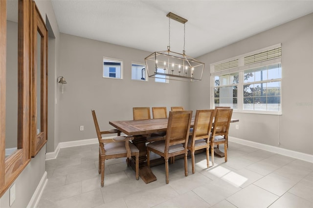 tiled dining room featuring a notable chandelier