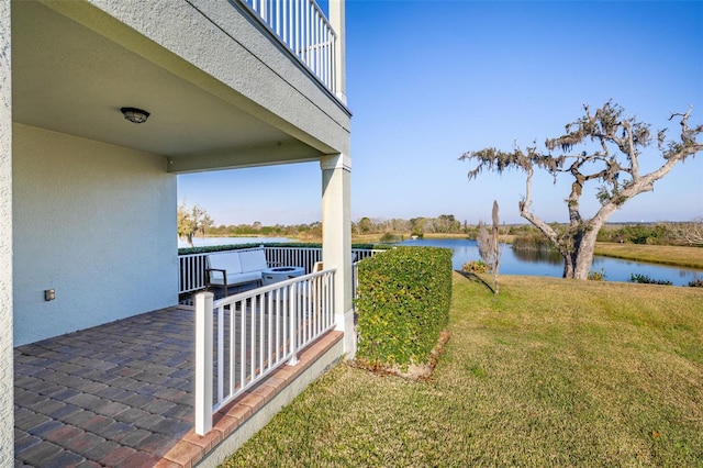 view of yard with a water view, a balcony, and an outdoor hangout area