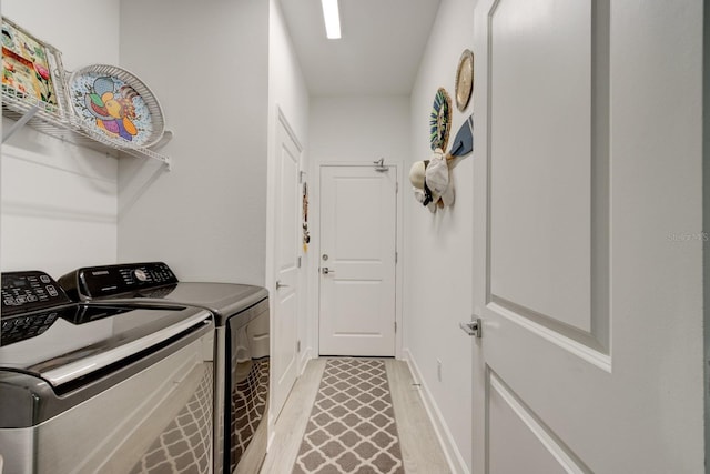 washroom with washer and dryer and light wood-type flooring