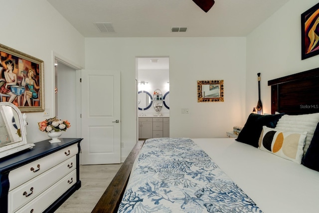 bedroom with ensuite bathroom, ceiling fan, and light wood-type flooring