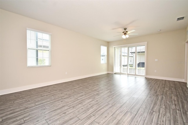 unfurnished room with ceiling fan, a healthy amount of sunlight, and light wood-type flooring