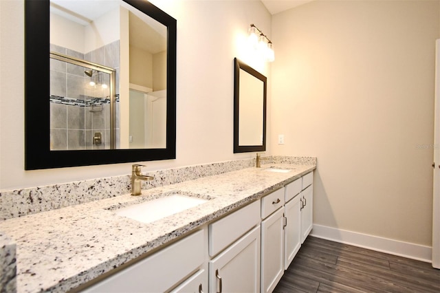 bathroom with an enclosed shower, vanity, and wood-type flooring