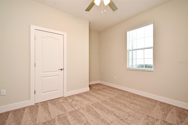 unfurnished room featuring ceiling fan and light colored carpet