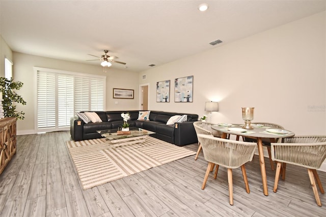 living area featuring visible vents, light wood-style flooring, and a ceiling fan