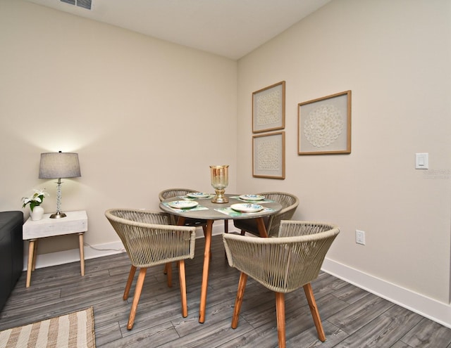 dining space with baseboards, visible vents, and wood finished floors