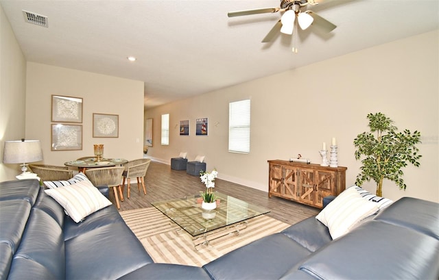 living area with visible vents, wood finished floors, and a ceiling fan