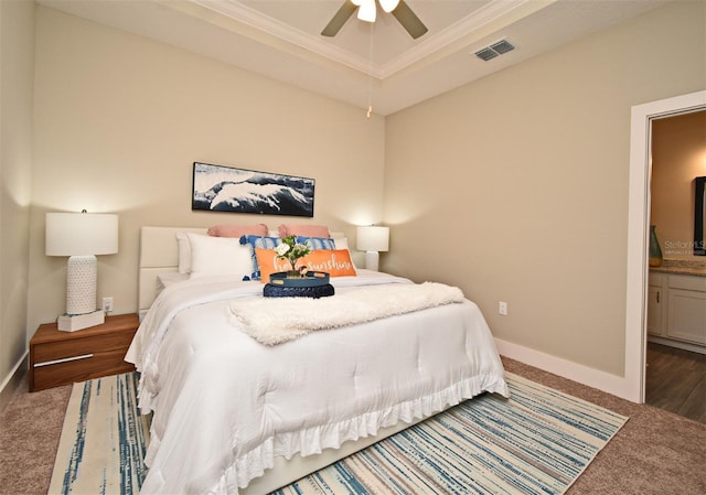 carpeted bedroom with connected bathroom, crown molding, baseboards, visible vents, and ceiling fan