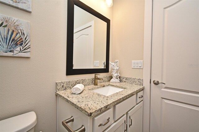 half bath featuring toilet and vanity