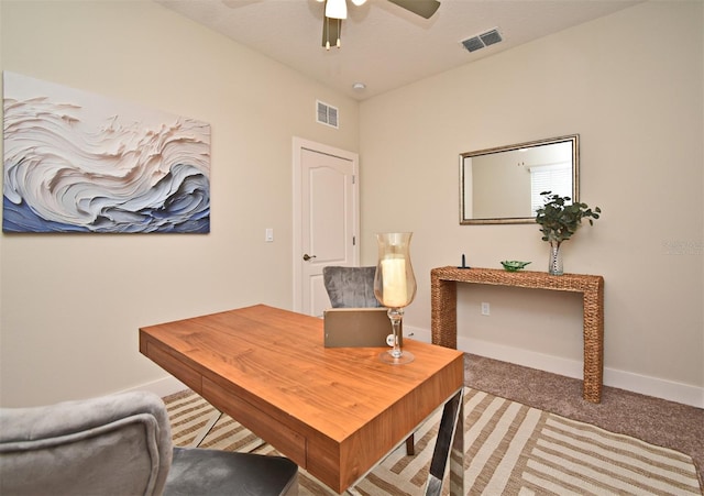 home office featuring light carpet, baseboards, visible vents, and ceiling fan