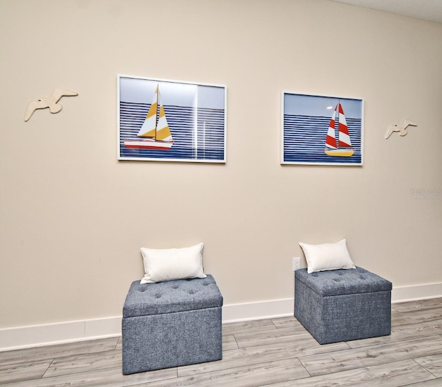 sitting room with baseboards and wood finished floors
