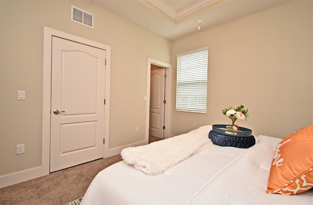 carpeted bedroom with baseboards, ornamental molding, visible vents, and a raised ceiling