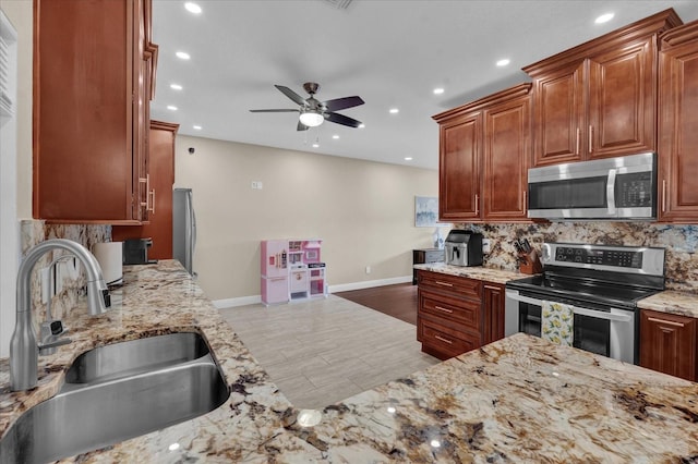 kitchen featuring tasteful backsplash, sink, ceiling fan, and appliances with stainless steel finishes