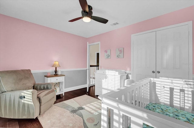 bedroom with a closet, dark hardwood / wood-style floors, and ceiling fan