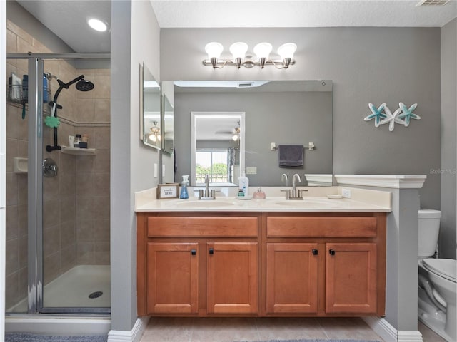 bathroom with vanity, toilet, an enclosed shower, and tile patterned flooring