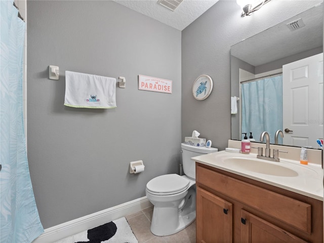 bathroom featuring vanity, toilet, tile patterned flooring, and a textured ceiling