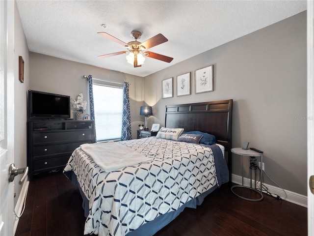 bedroom with a textured ceiling, dark wood-type flooring, and ceiling fan