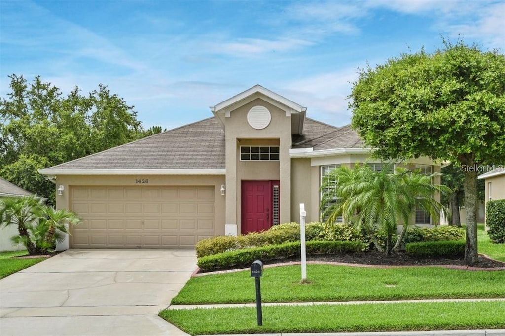 view of front of home with a garage and a front yard