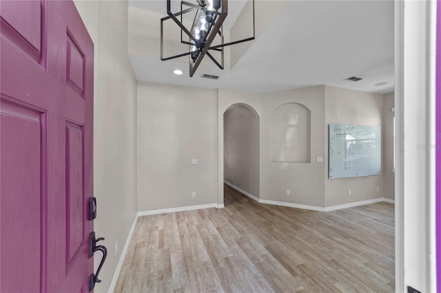 foyer entrance featuring an inviting chandelier and light hardwood / wood-style floors