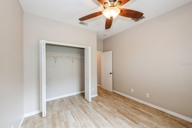 unfurnished bedroom with ceiling fan, light wood-type flooring, and a closet