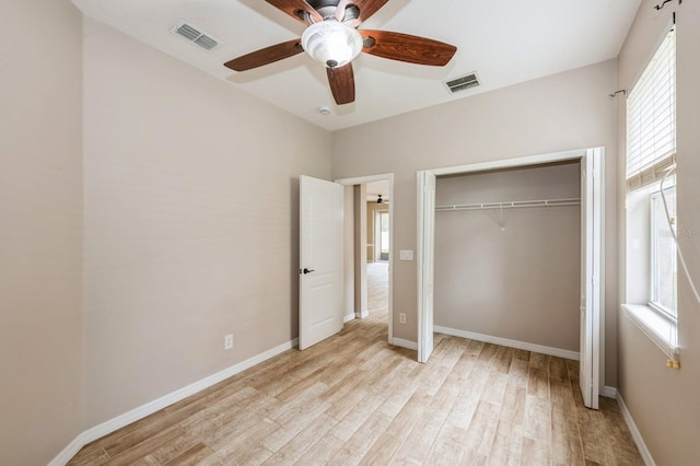 unfurnished bedroom with multiple windows, light hardwood / wood-style flooring, a closet, and ceiling fan