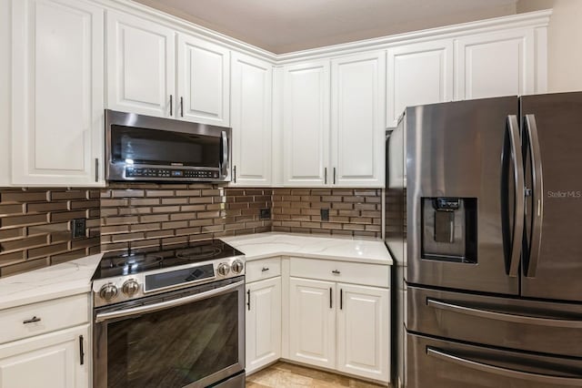 kitchen with light stone counters, stainless steel appliances, backsplash, and white cabinets