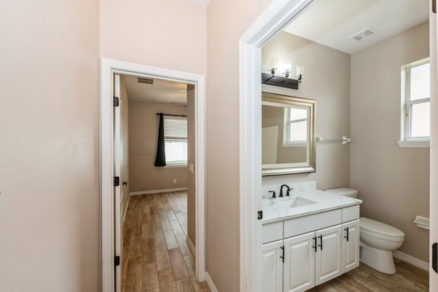 bathroom with wood-type flooring, toilet, and vanity