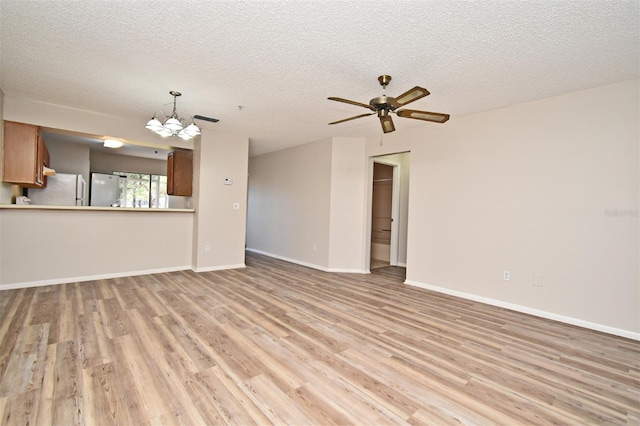 unfurnished living room with a textured ceiling and light hardwood / wood-style floors