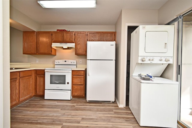 kitchen with white appliances, stacked washer / drying machine, and light hardwood / wood-style floors