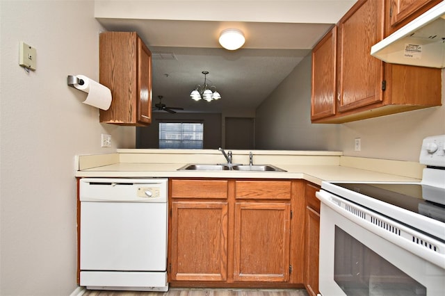 kitchen with pendant lighting, white appliances, ceiling fan with notable chandelier, and sink