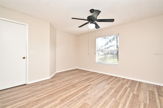 unfurnished room with ceiling fan, a textured ceiling, and light wood-type flooring