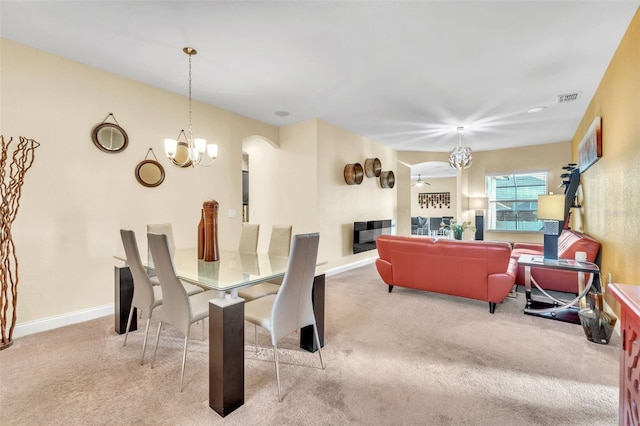 carpeted dining area featuring a chandelier