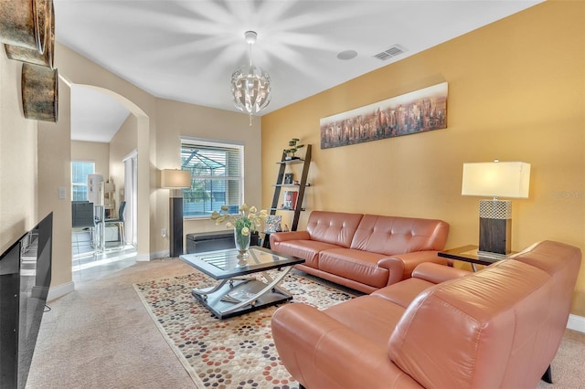 living room featuring a multi sided fireplace, light colored carpet, and a chandelier