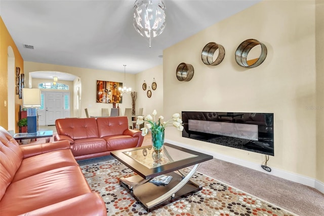 carpeted living room with a notable chandelier