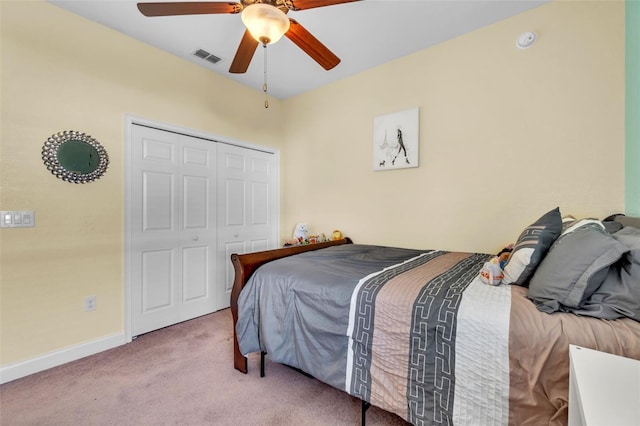 carpeted bedroom featuring ceiling fan and a closet