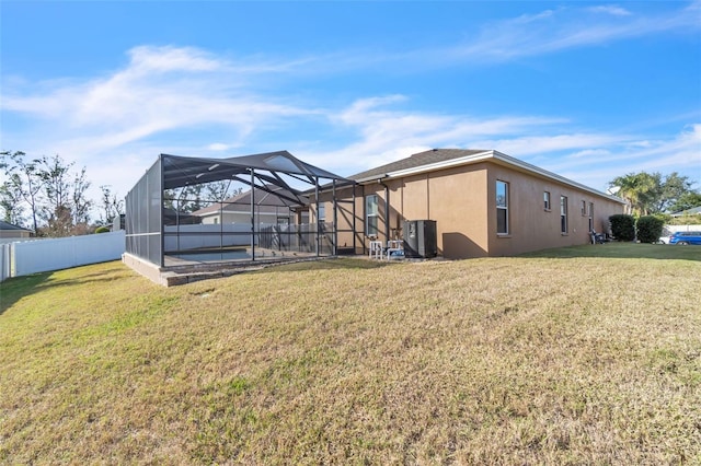 rear view of property with a pool, a yard, and a lanai