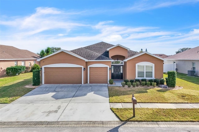 ranch-style home featuring a garage, central air condition unit, and a front lawn