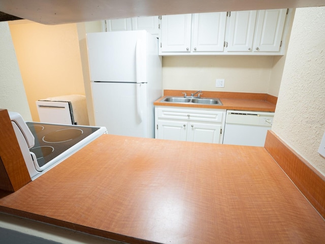 kitchen featuring white appliances, sink, and white cabinets