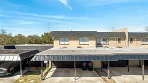 back of house featuring a carport