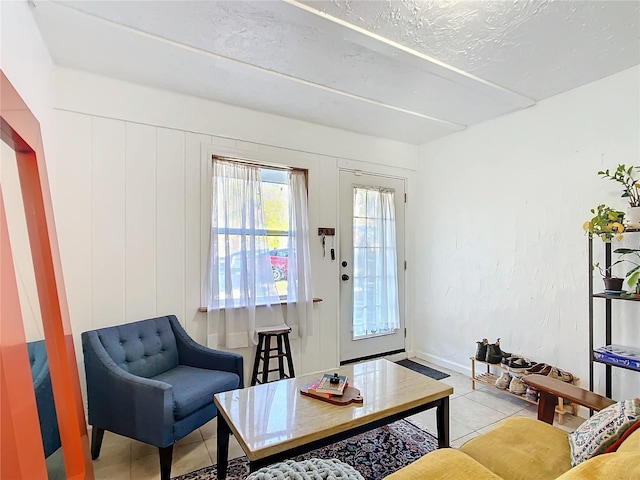 tiled living room with a textured ceiling and baseboards